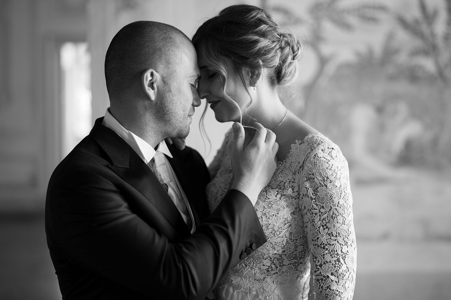 Romantic black and white portrait of newlyweds sharing intimate moment.