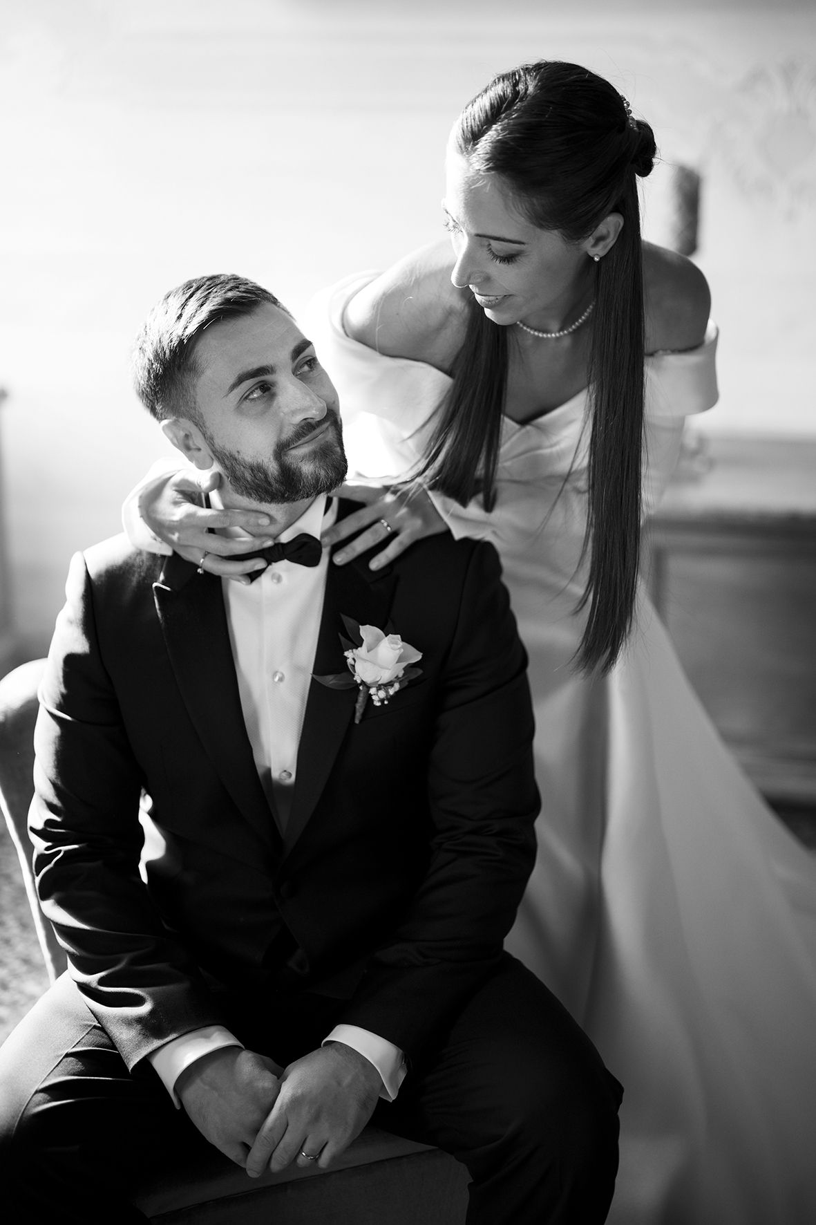 Black and white intimate portraits of newlyweds sharing tender moments in formal attire.