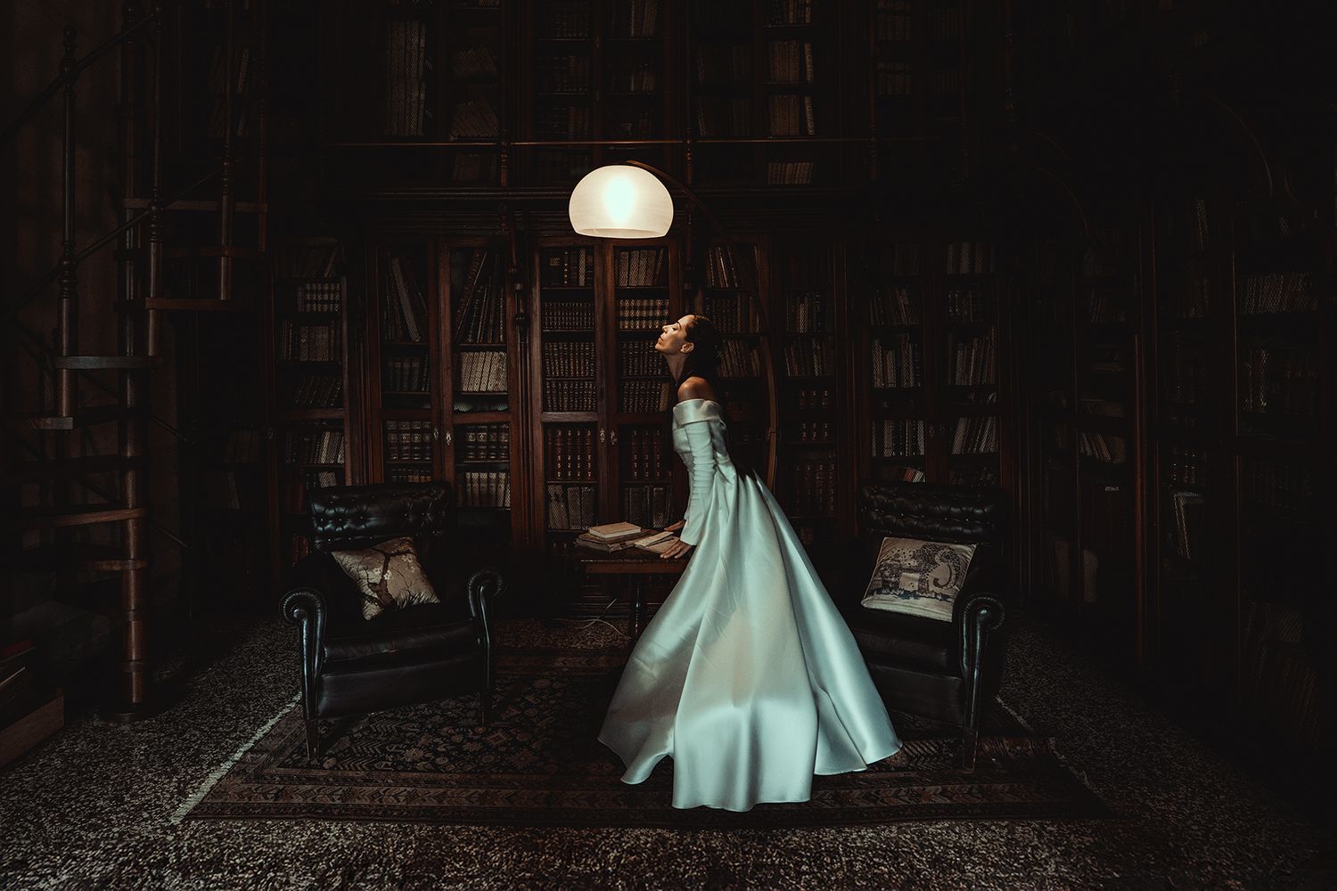 Dark library interior with glowing dome lamp creating atmospheric lighting.
