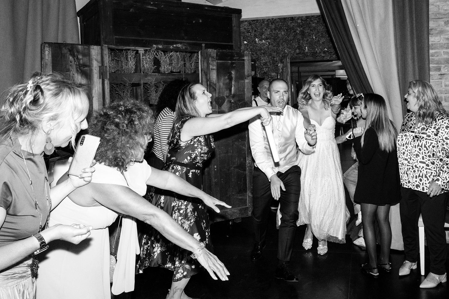 Black and white photo of energetic wedding reception dancing and celebration.
