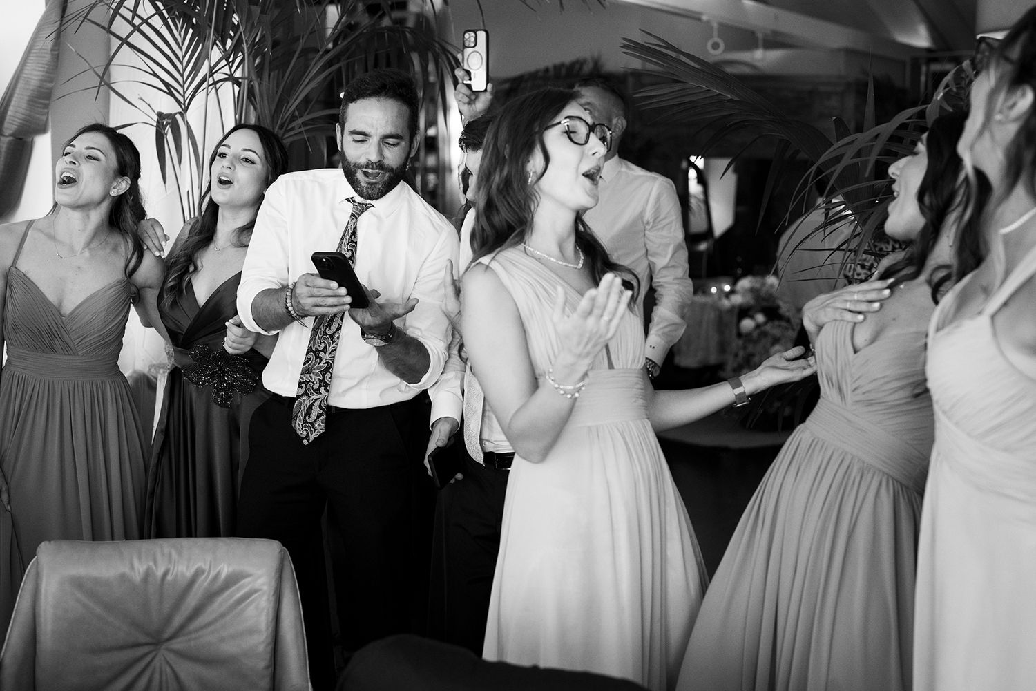 Black and white photos capturing joyful moments of dancing at a wedding reception.