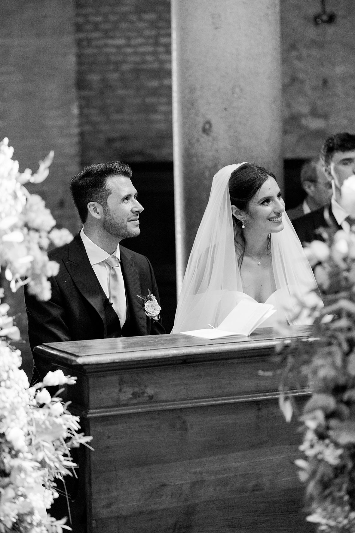 Wedding ceremony in a historic brick church with floral decorations.