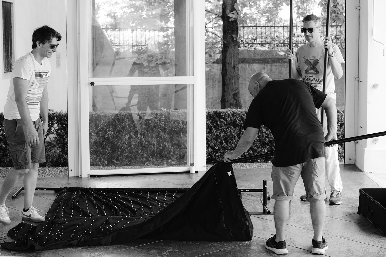 People working outdoors with cleaning equipment near a window.