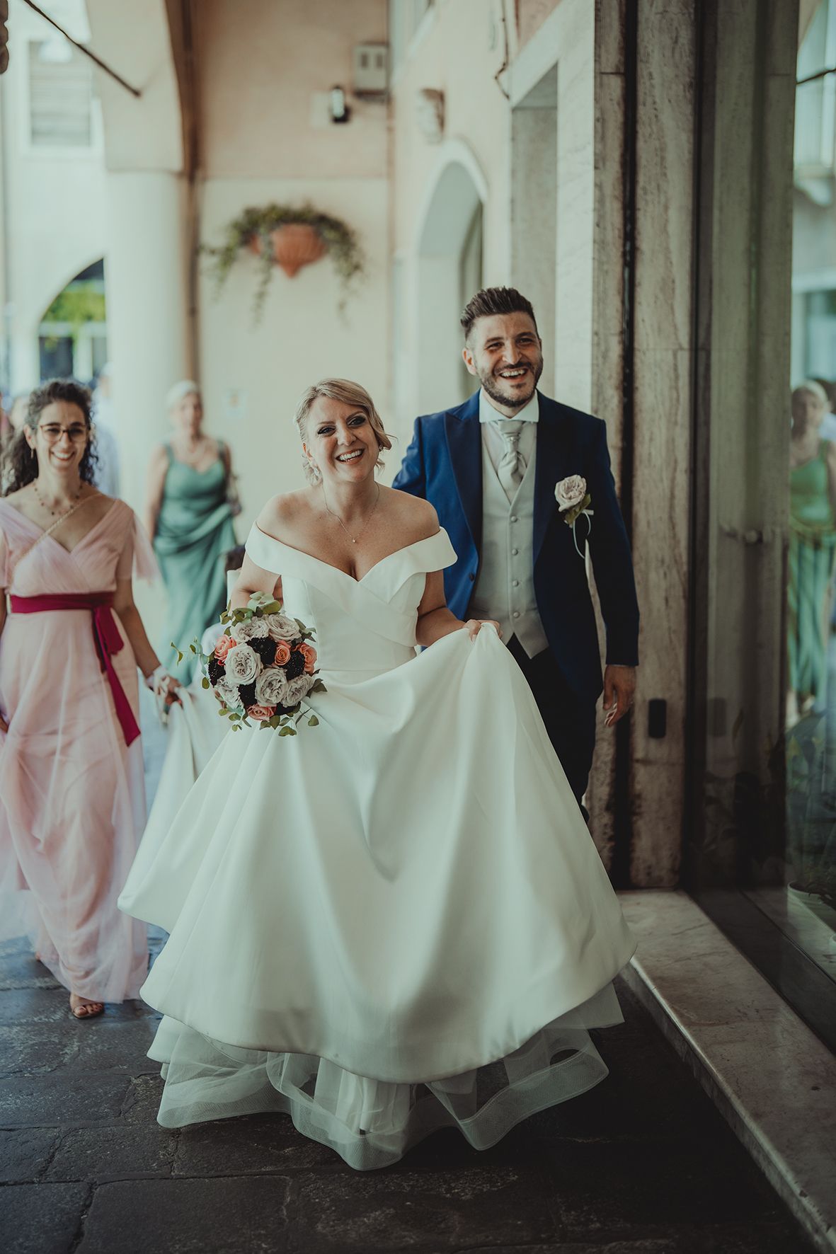 Candid wedding party moments captured in an elegant corridor.