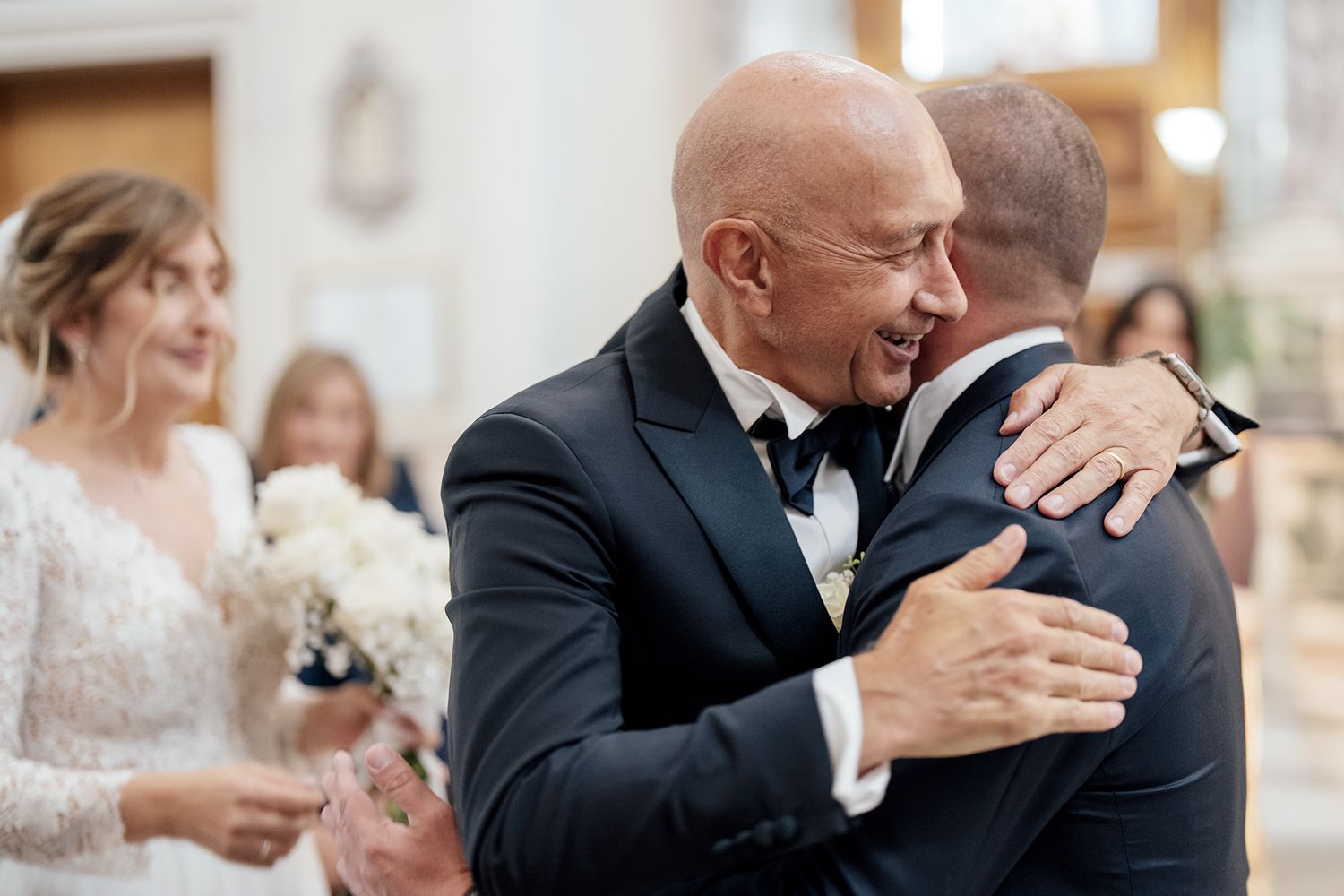 A couple shares an emotional moment during their wedding ceremony in a church.