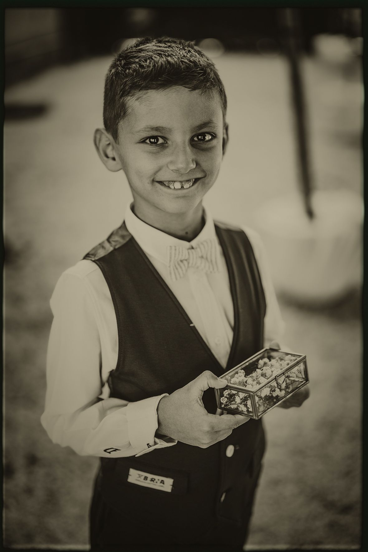 A series of black and white portraits showing someone in a formal vest and white shirt holding a serving tray.
