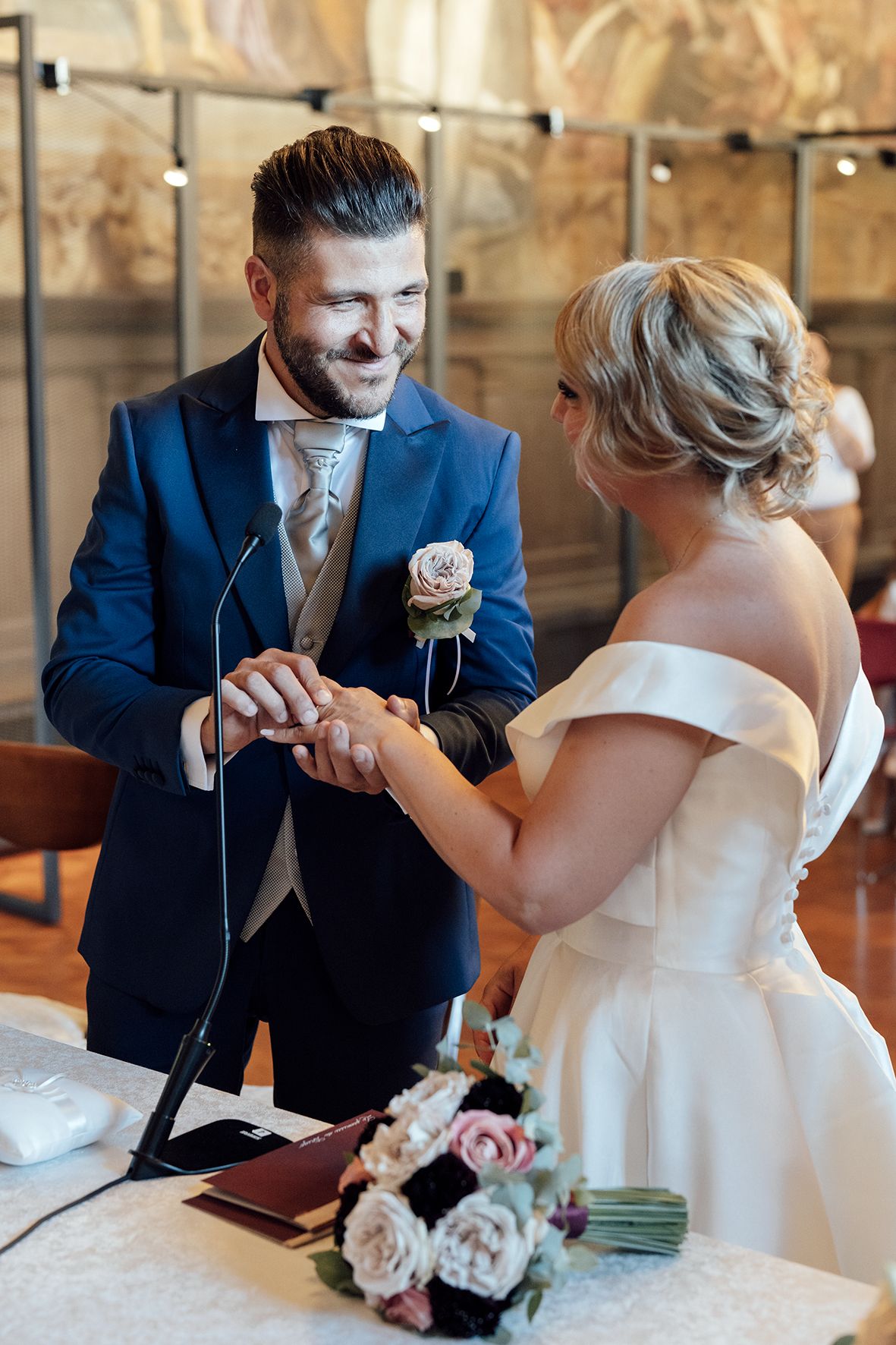 A romantic wedding scene with a couple in navy and white attire sharing a tender moment.