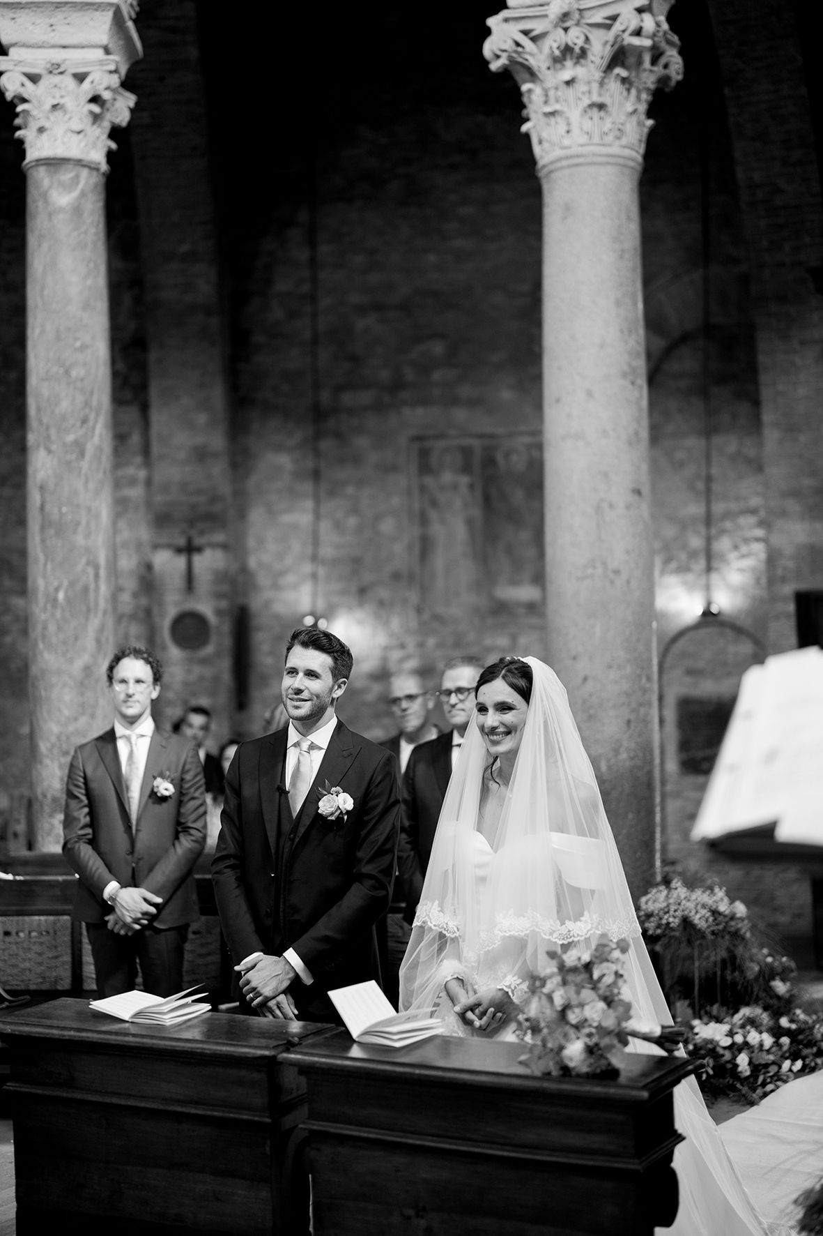 Wedding ceremony in historic church with ornate stone columns.