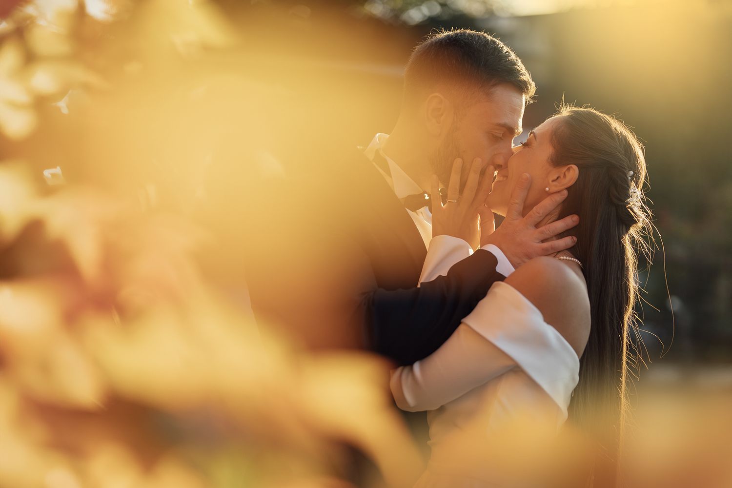 Romantic golden hour wedding portrait with soft focus and warm lighting.