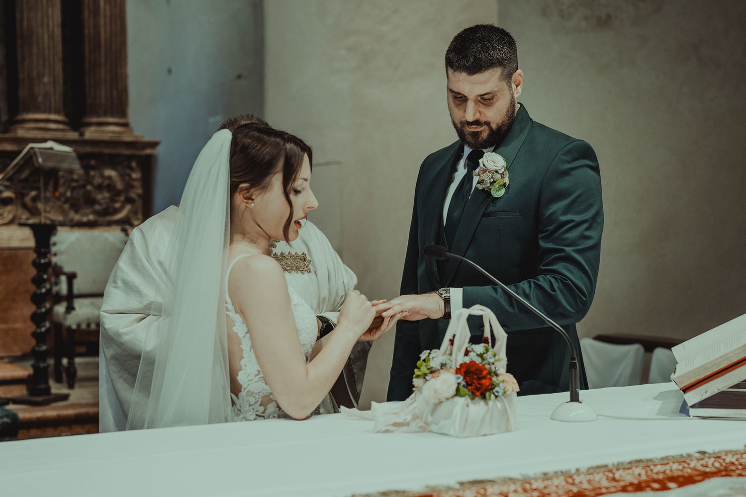 A tender moment during a wedding ceremony as rings are exchanged at the altar.