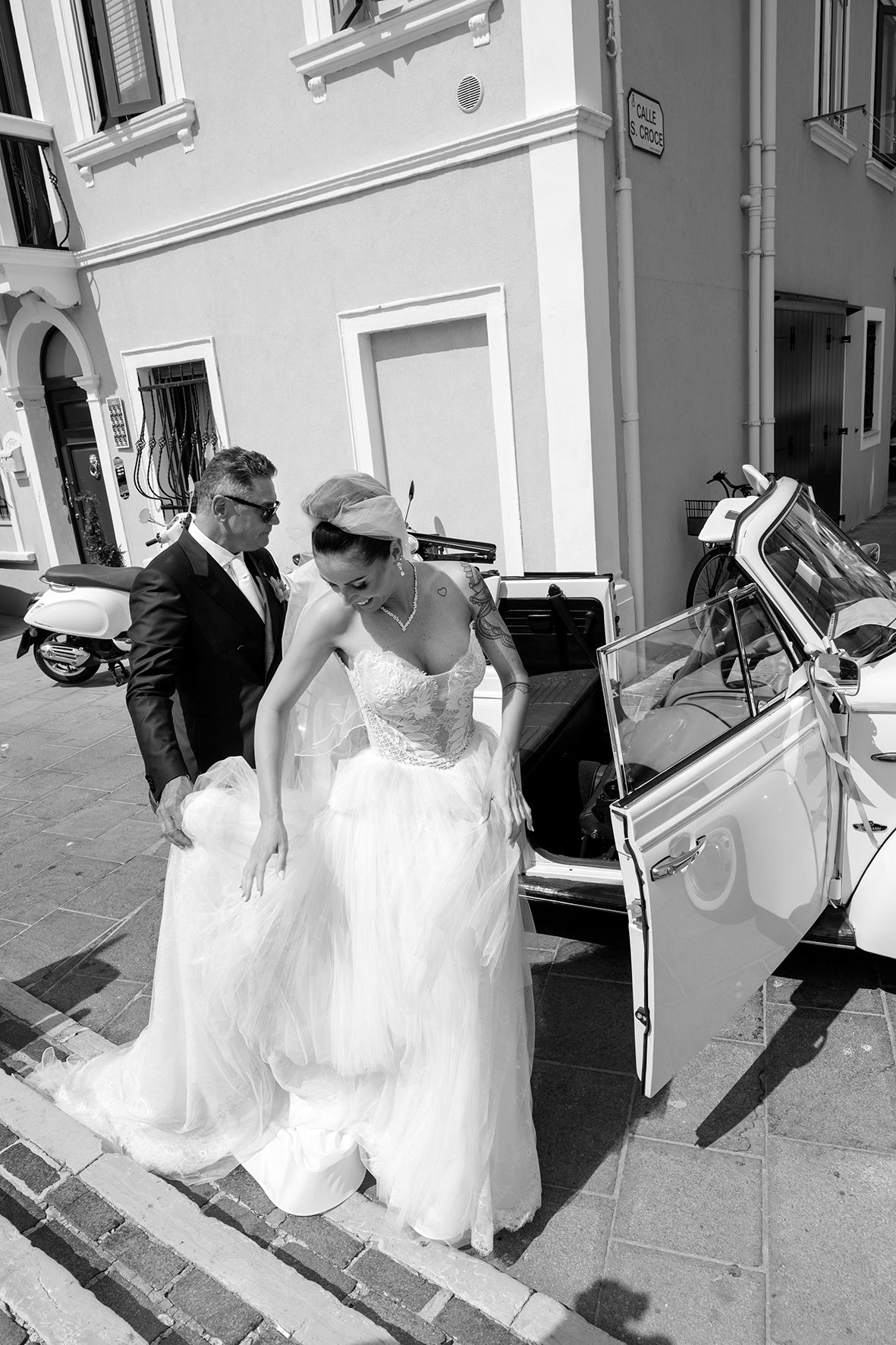 Young attendants in white dresses walking together on sunny church steps.