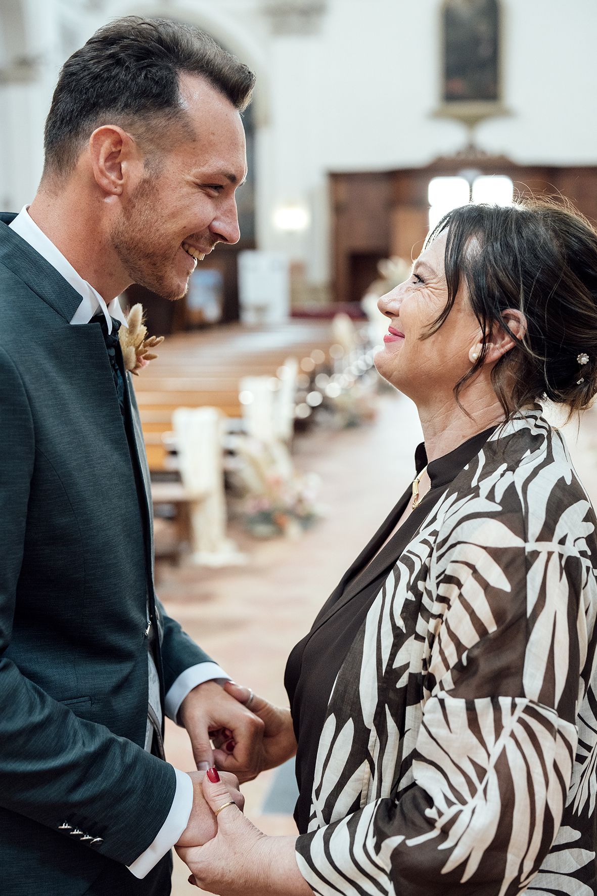 Couple in formal attire sharing an intimate moment in a church setting.