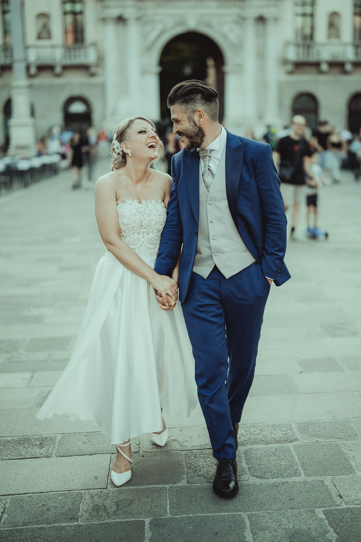 A romantic moment between newlyweds on a historic European square.