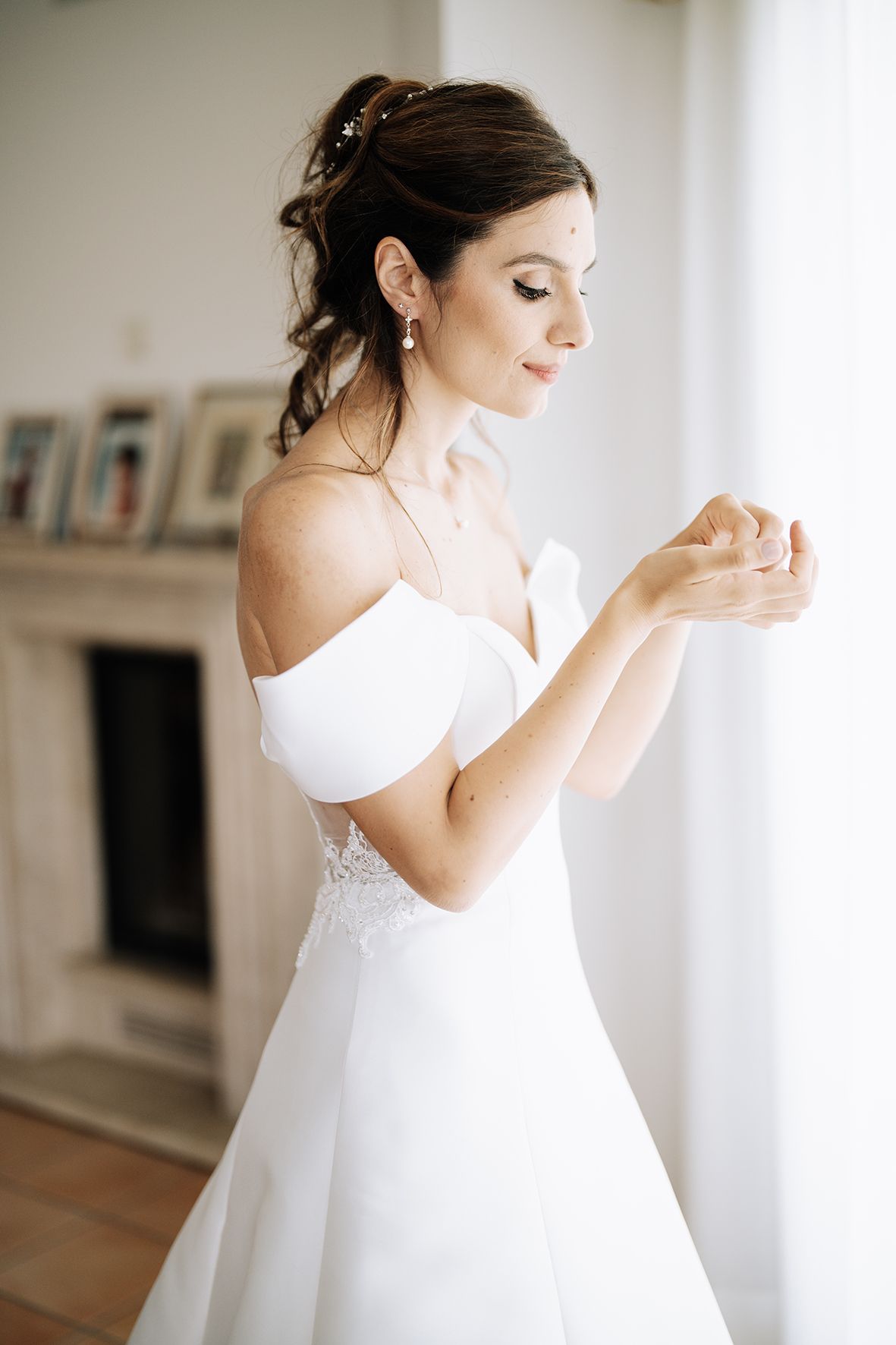 Artistic sequence of bride in white dress preparing for wedding day in natural window light.