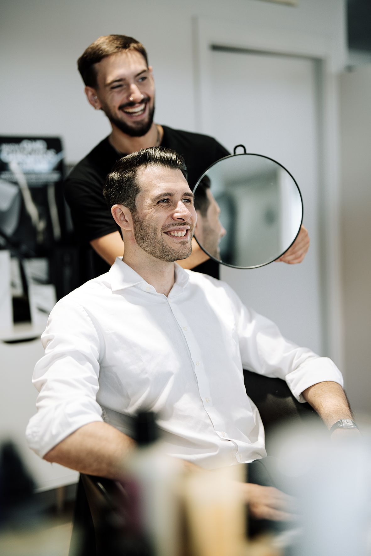 Client and stylist share a lighthearted moment during haircut service.