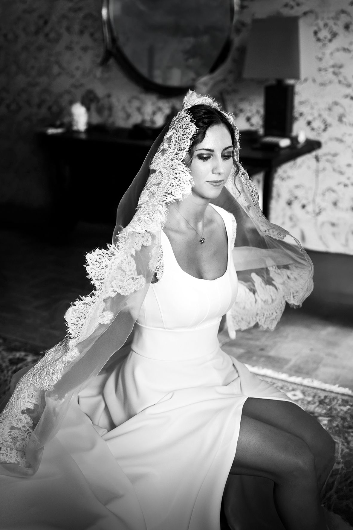 Black and white photos of a wedding dress with delicate lace details in an elegant setting.
