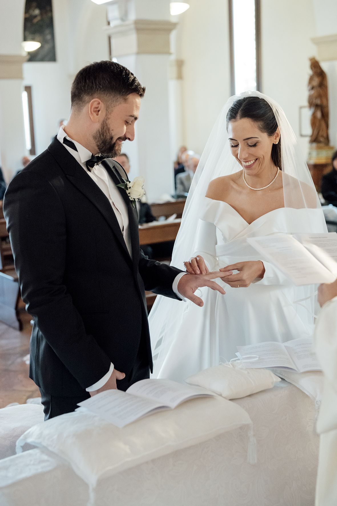 Candid wedding moments showing couple sharing laughter in bright church interior.
