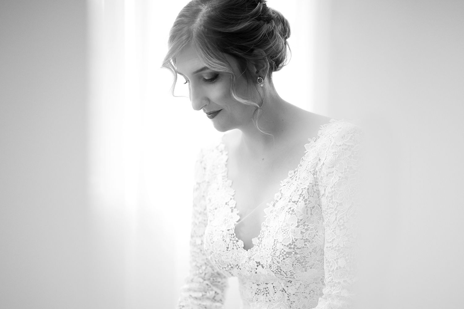 Ethereal high-key portrait showing delicate lace details of a white dress.