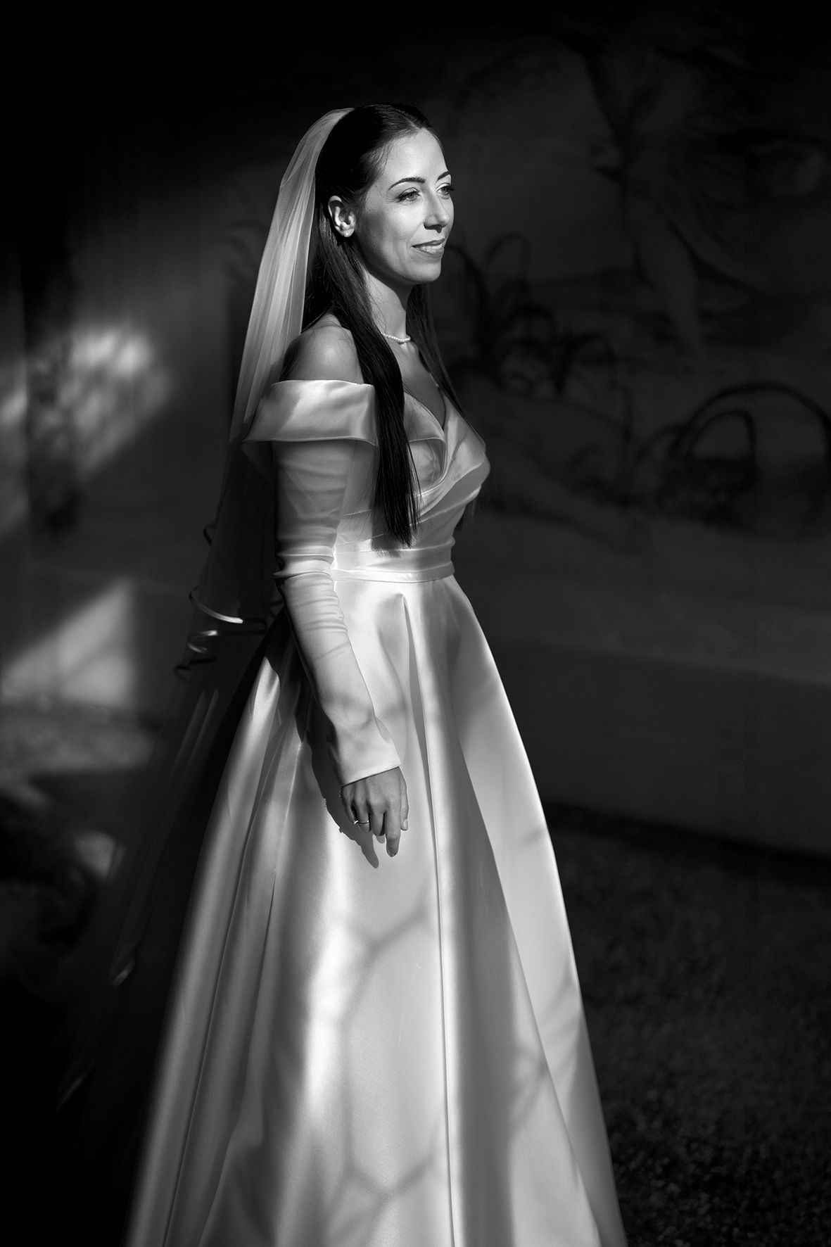 Elegant black and white photos of a bride in a luxurious satin wedding gown with flowing details.