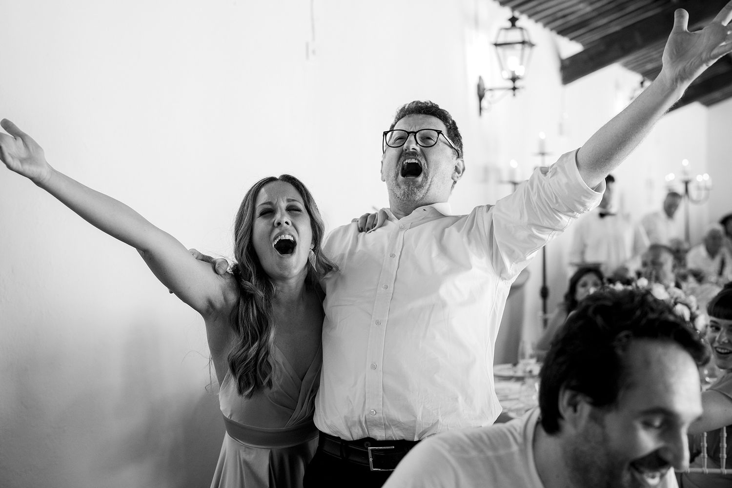 Joyful celebration moment captured in black and white with raised arms and expressions of happiness.
