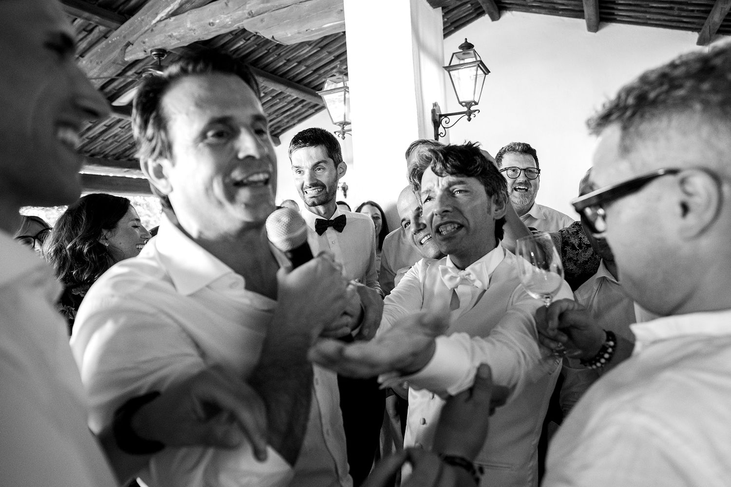 Energetic group of wedding guests dancing and celebrating together at an indoor venue.