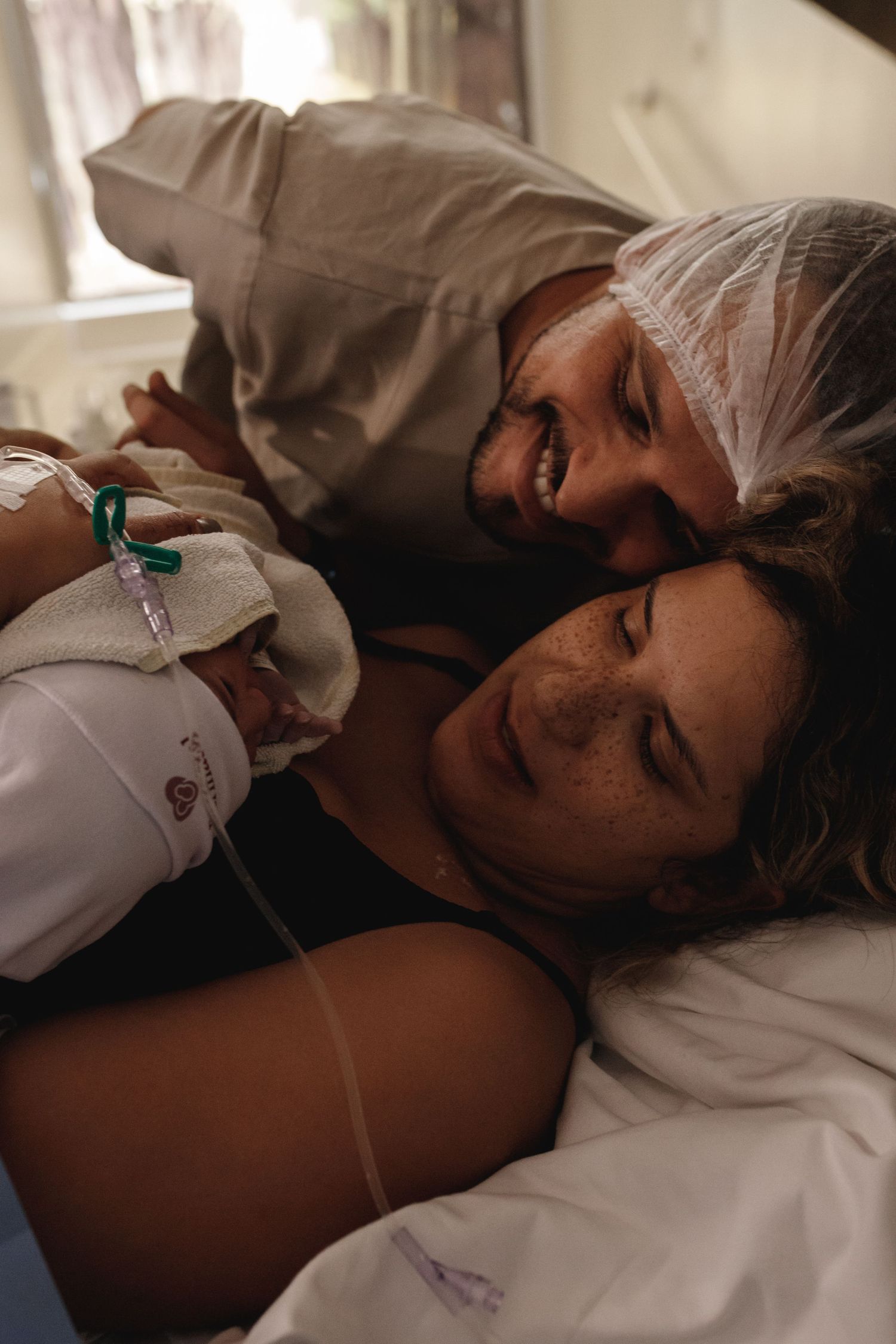 Healthcare providers wearing protective equipment attend to a patient in a medical setting.