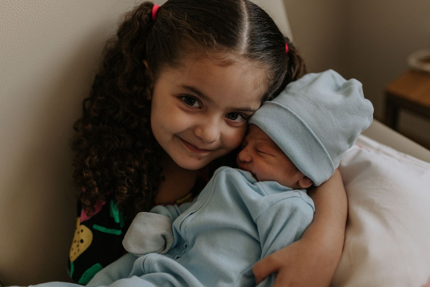 A tender moment captured between parents and their newborn baby in a cozy home setting.