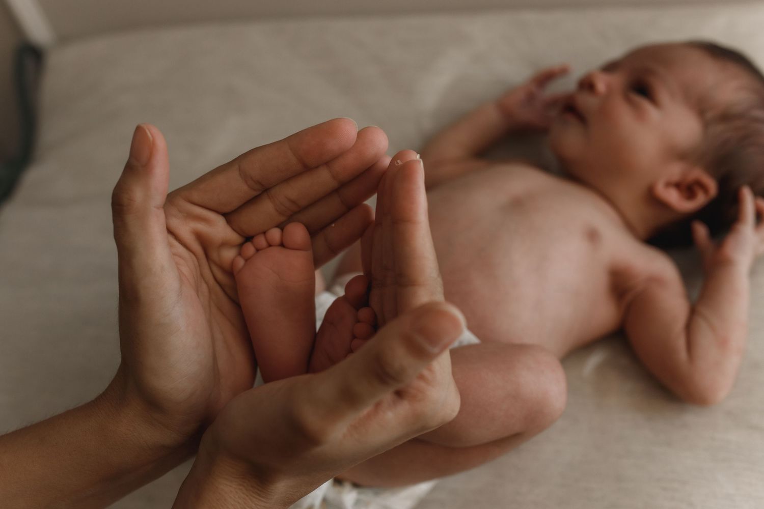 Close-up details of newborn baby features in soft, natural lighting.