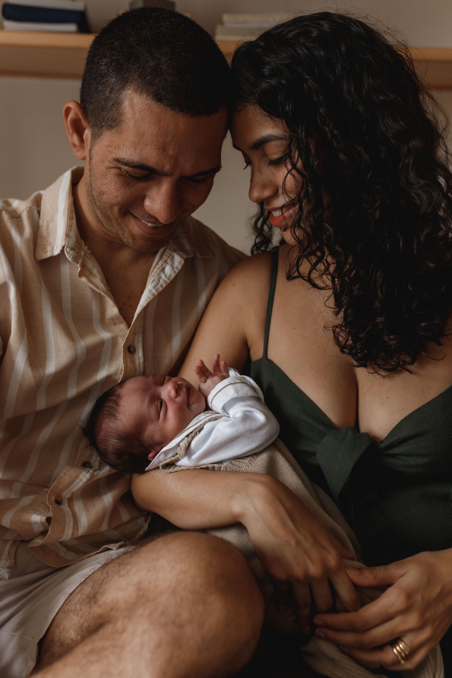 Intimate nursing session photographed in moody indoor lighting.