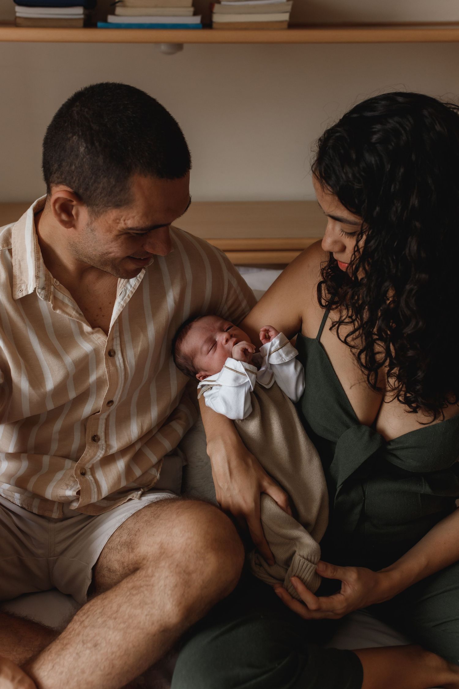 Tender family moment shared on couch in muted earth tones.