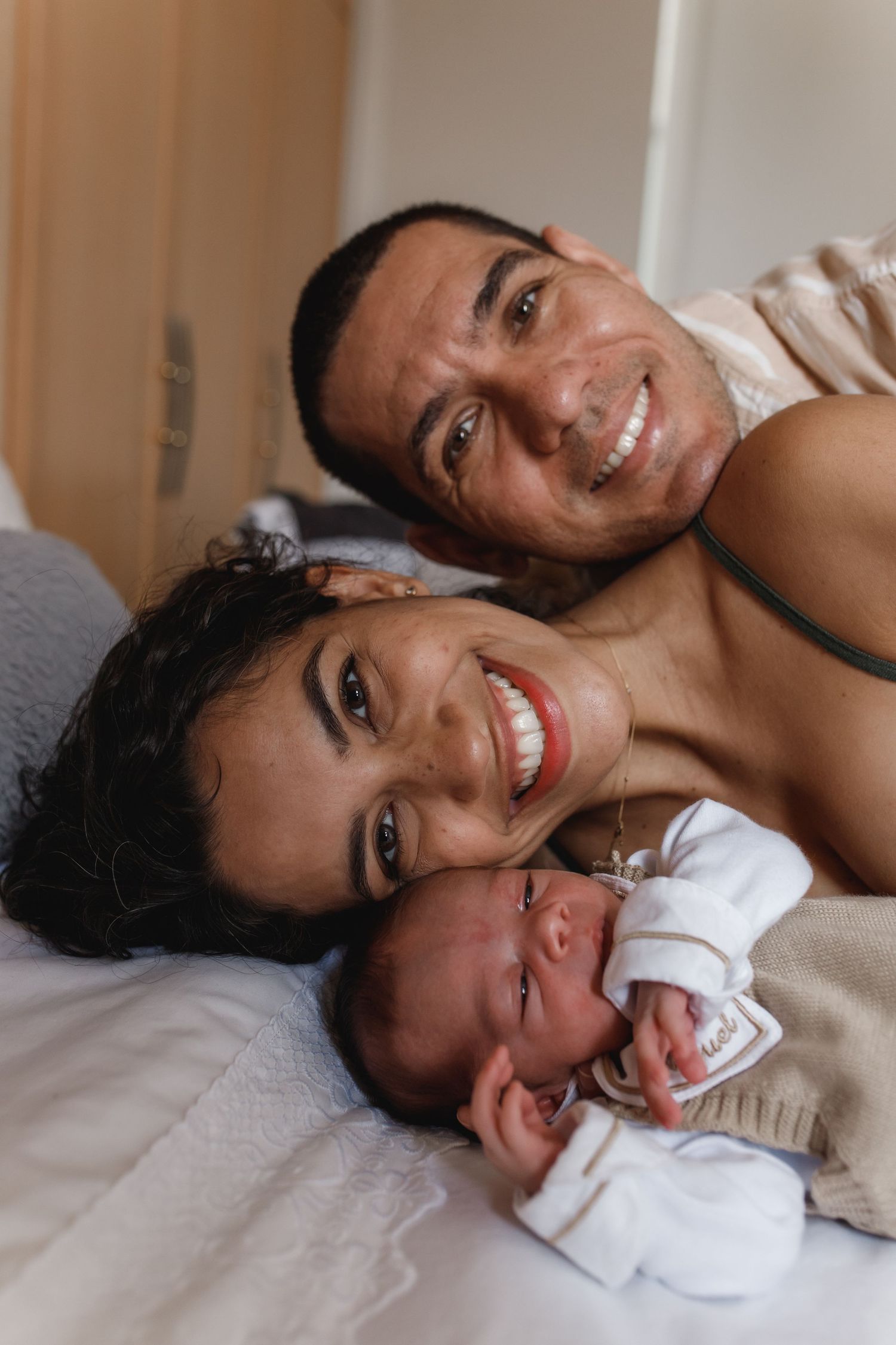 Cozy lifestyle portraits captured on soft white bedding in warm natural light.