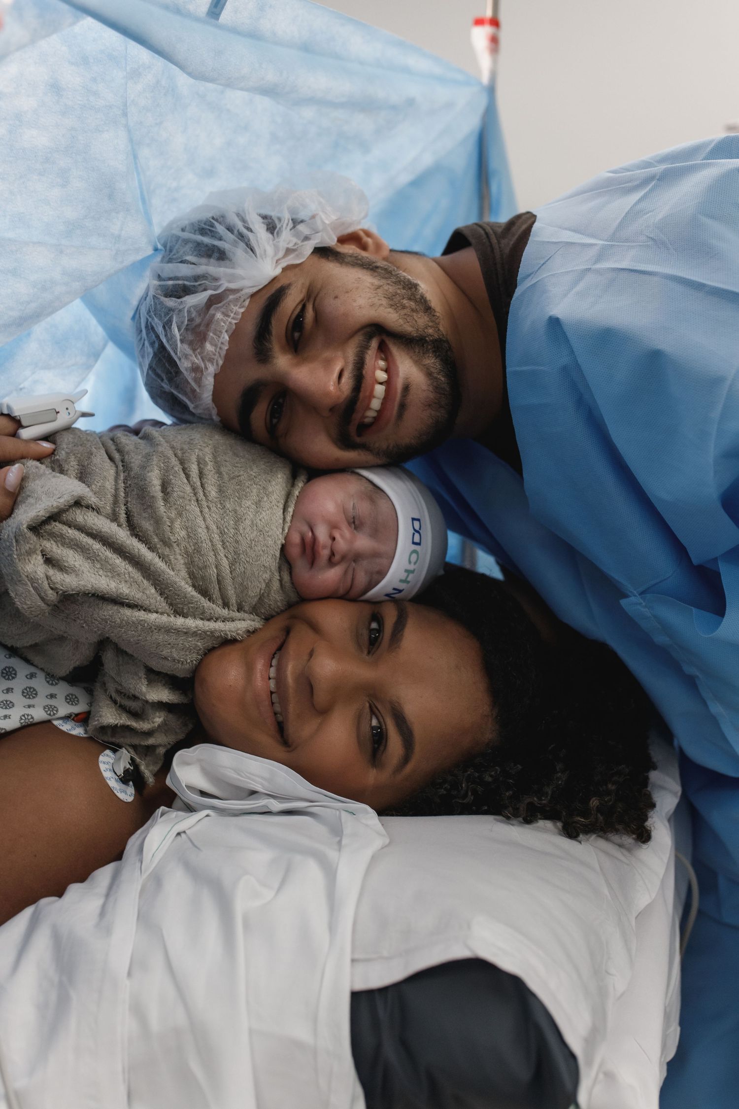 Medical staff in blue scrubs caring for a patient in a hospital setting.