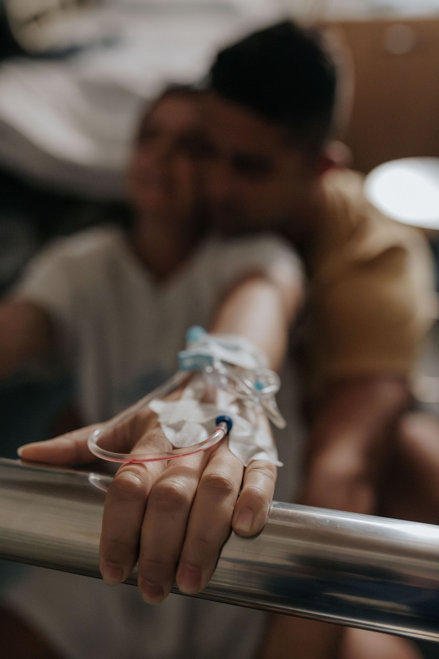 Close-up detail shot of hands gripping a metal bar with shallow depth of field.