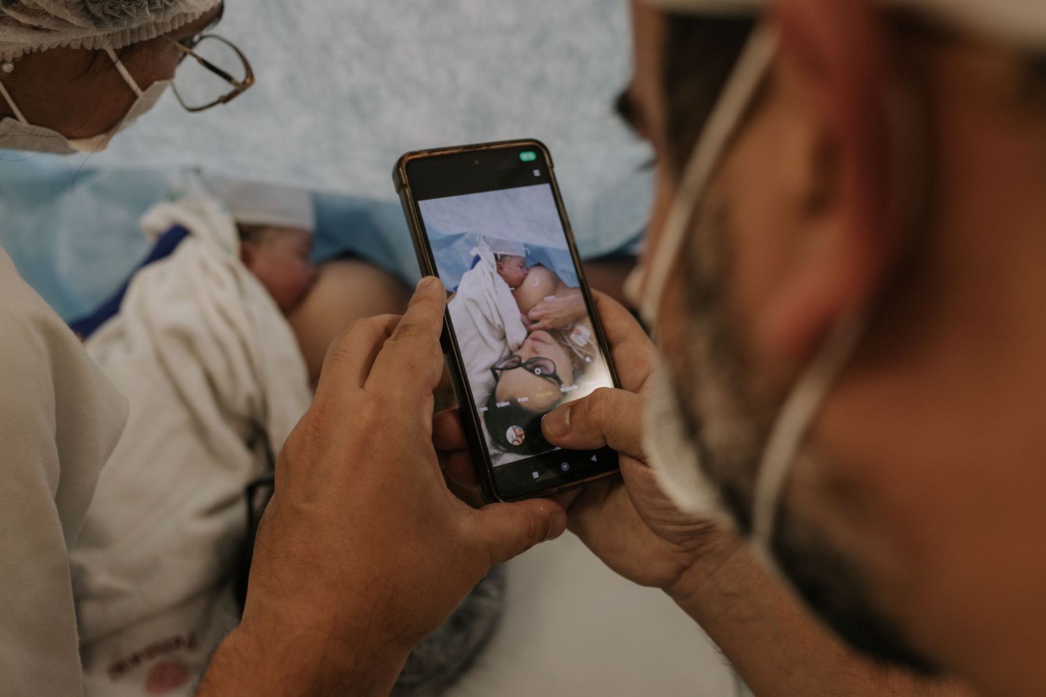 Close-up of hands holding smartphones to capture hospital moments.