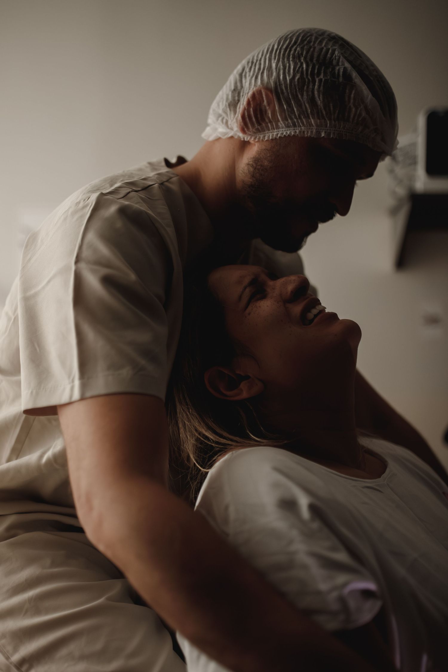 Medical professionals in protective gear tend to a patient during a medical procedure.