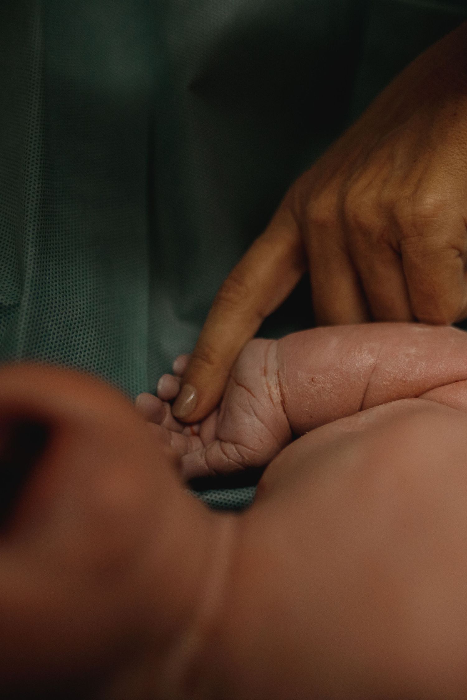 Medical hands performing a delicate procedure in a dimly lit clinical setting.