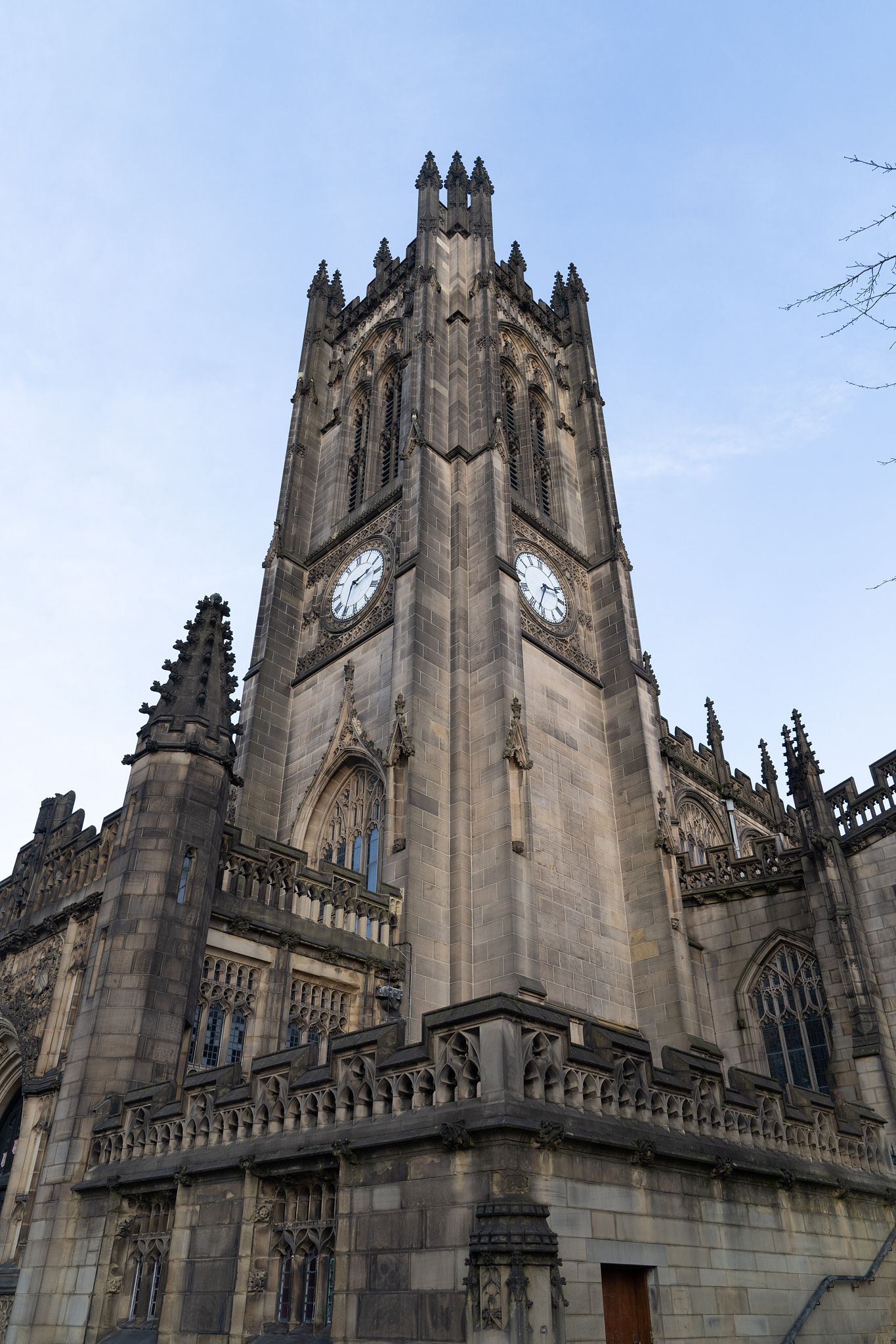 Gothic cathedral spires and ornate stonework reach skyward against a bright blue background.