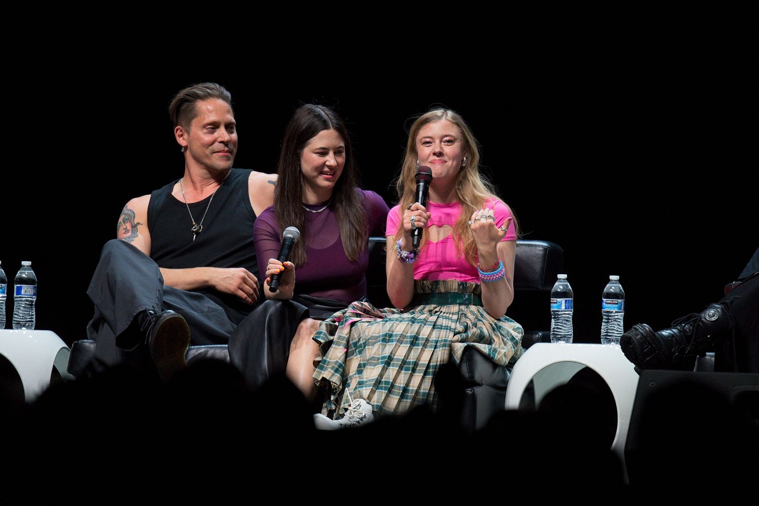 Group discussion panel seated on stage during a conference event.