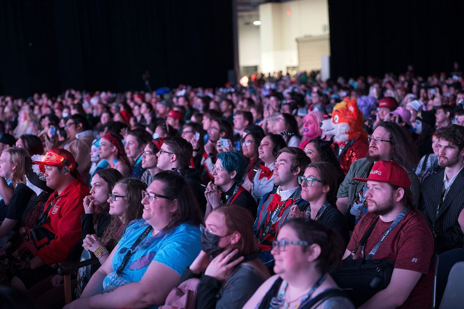 Large audience seated in darkened auditorium during an event.