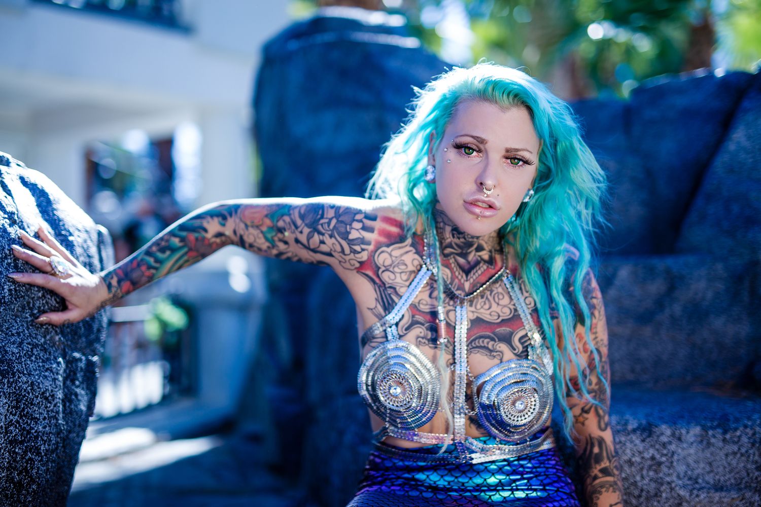 Alternative style portrait with bright teal hair and artistic lighting.