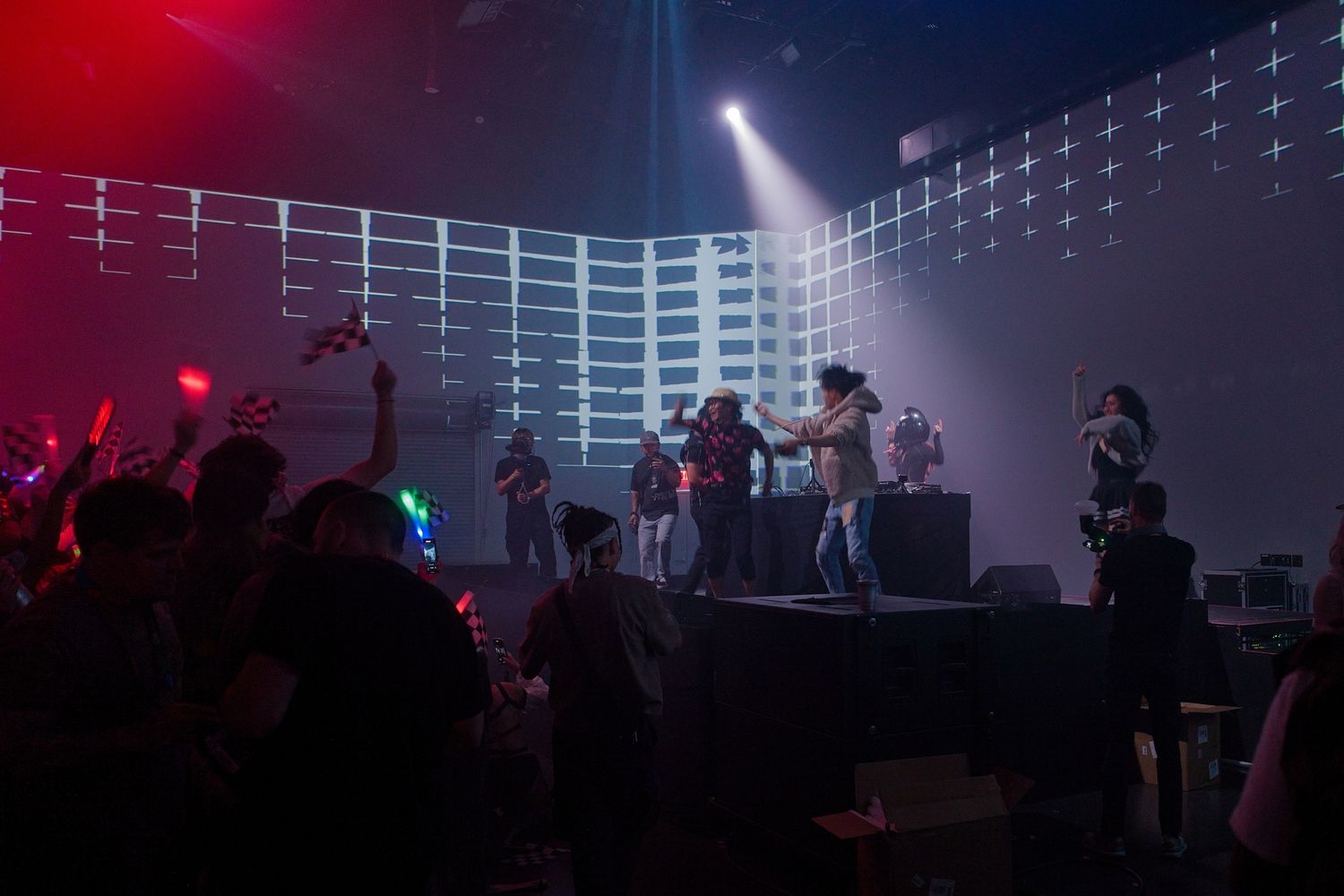 Concert venue with dramatic red and blue lighting effects illuminating the stage.