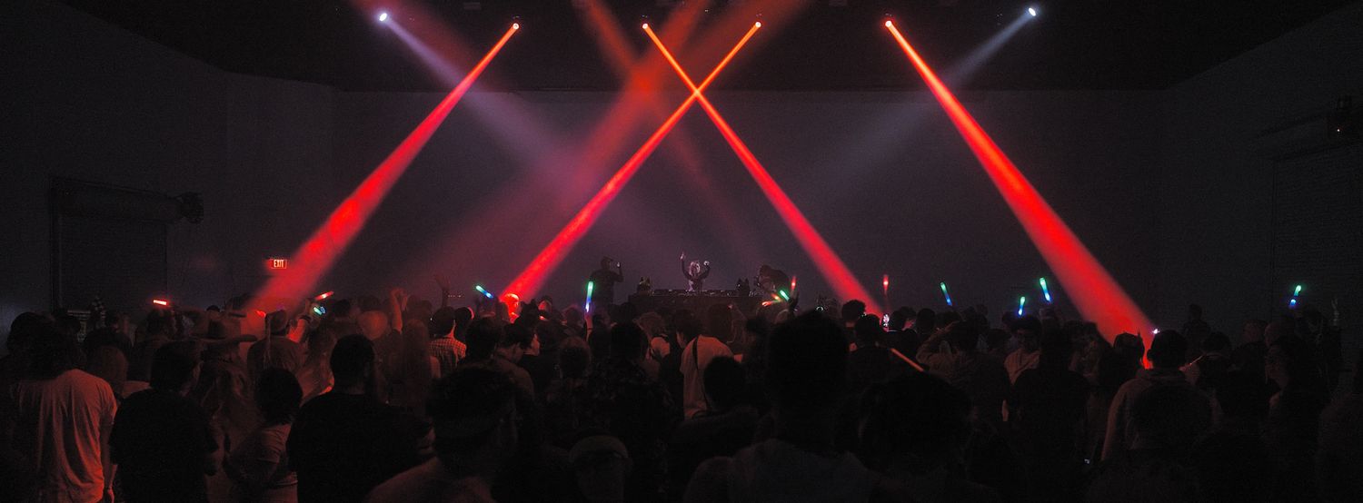Red laser light beams cutting through darkness at an entertainment venue.