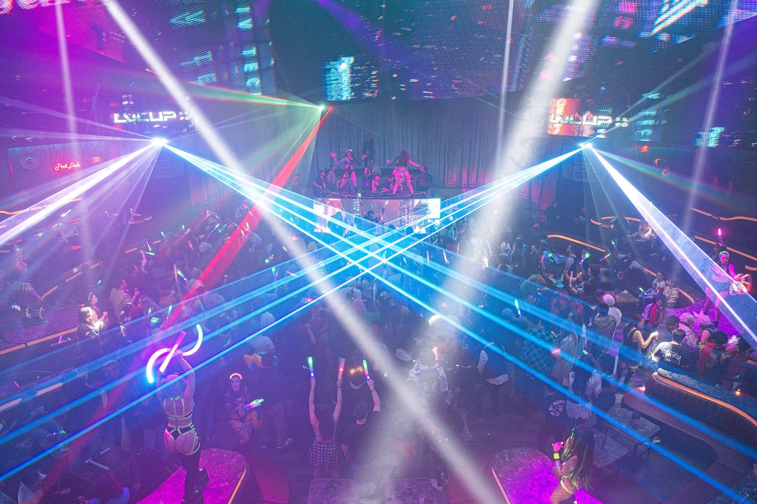 Nightclub or concert venue with vibrant purple and blue laser light show effects.