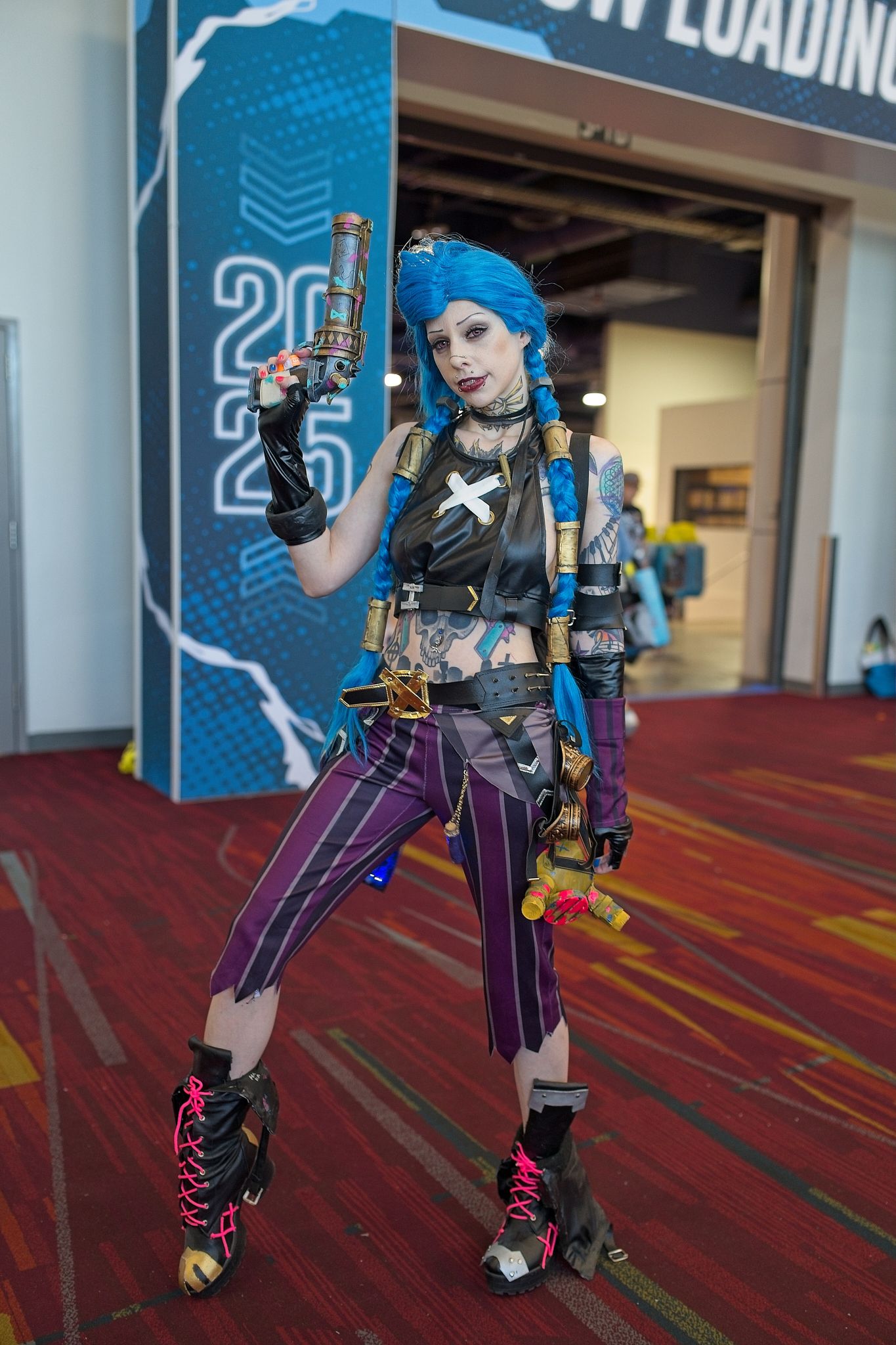 Detailed video game character cosplay with armor and props on red carpet.