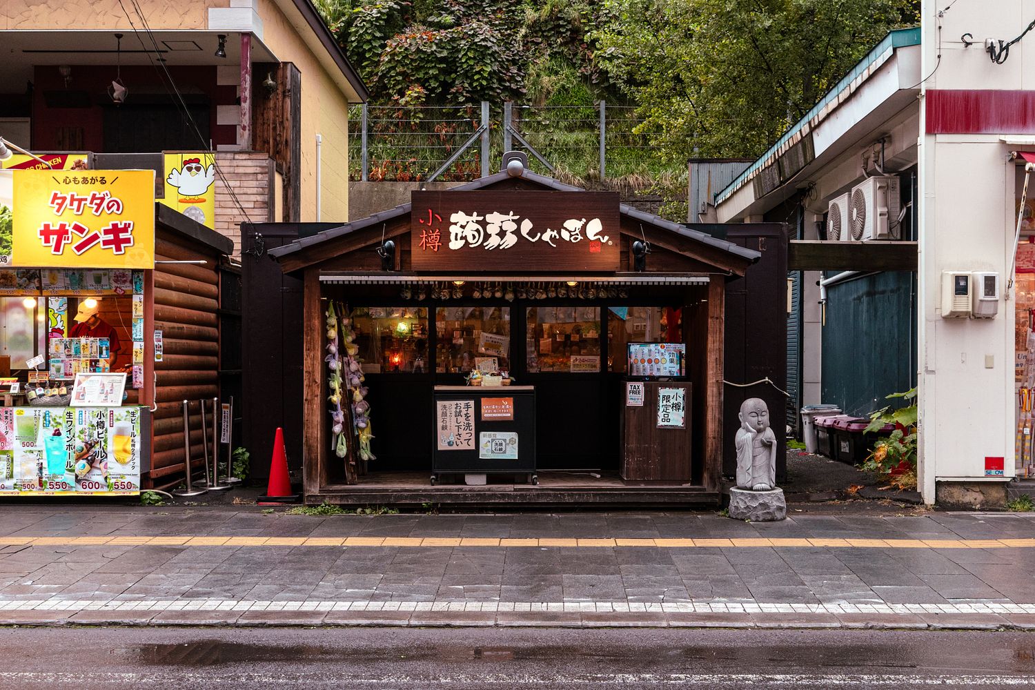 Row of traditional Japanese storefronts and shops along a quiet street.