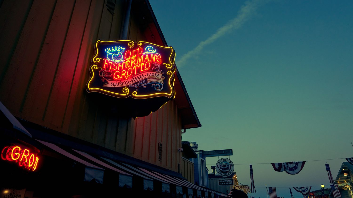 Vintage neon signs glowing against a twilight sky.