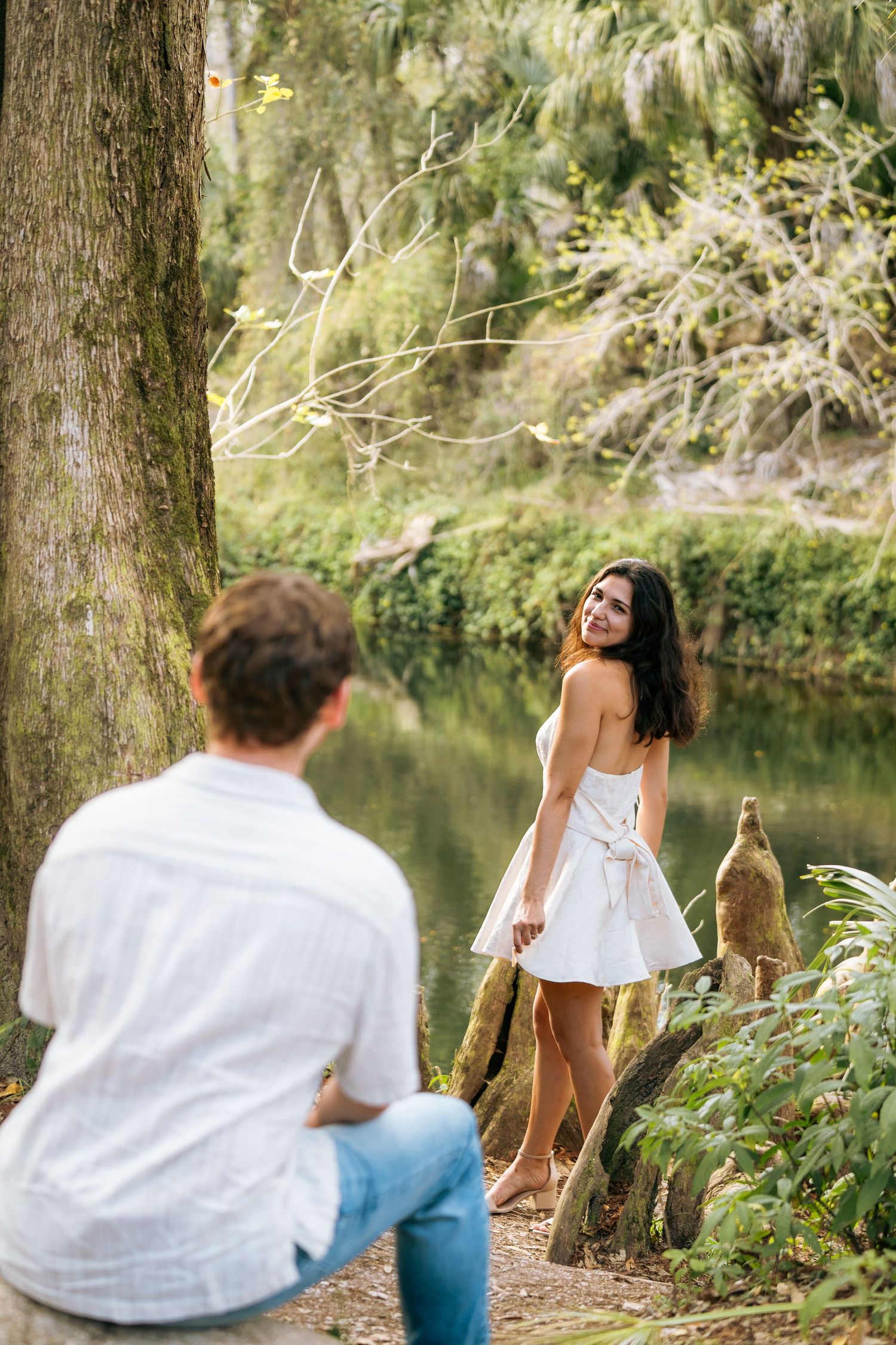 A romantic picnic scene by the water with wine bottles and natural scenery.