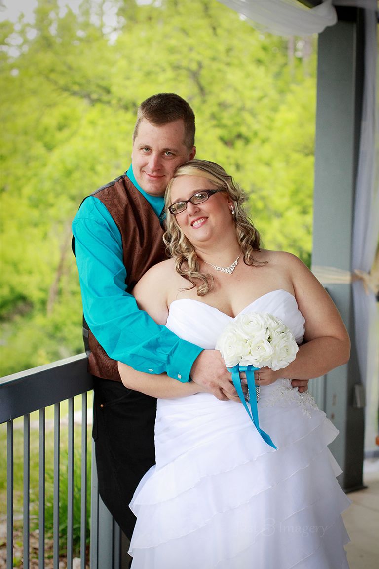 wedding couple standing at their ceremony site under a gazebo in the park