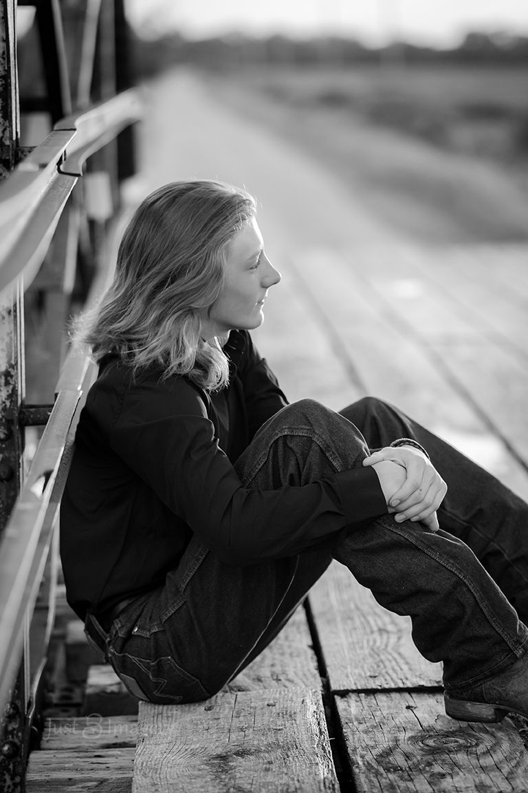 high school senior boy on a bridge, moody black and white portrait
