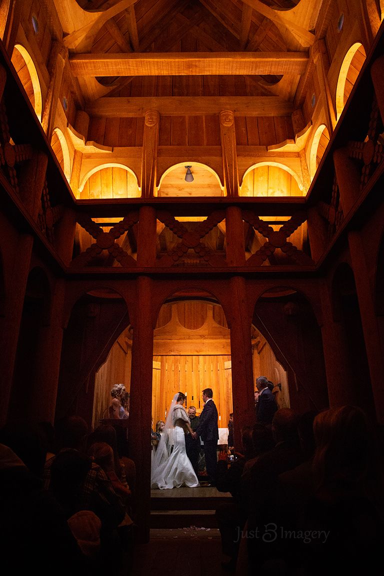 wedding ceremony inside ancient wooden cathedral, dramatic lighting